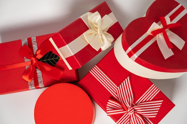 Red and striped boxes with gifts tied bows on white background