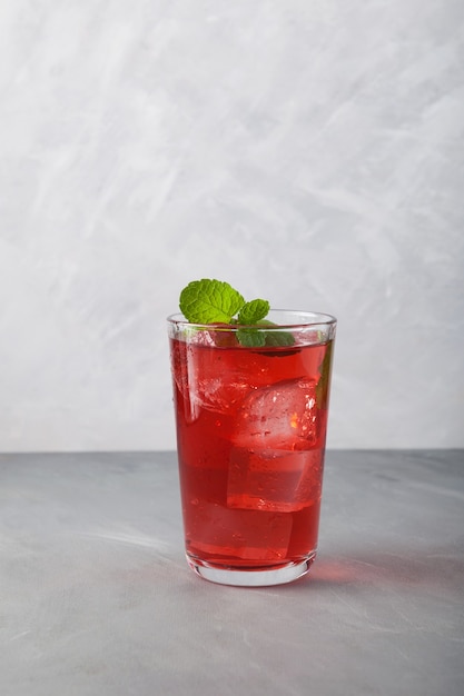 Red summer nonalcoholic refreshing drink with ice or fruit iced tea, closeup