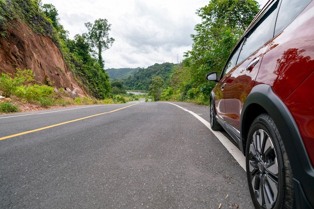 Red Suv car on Asphalt road with mountain green forest Transportation 