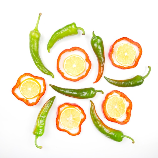 Red sweet and green hot peppers and lemon on a white background. cooking vegetables for food