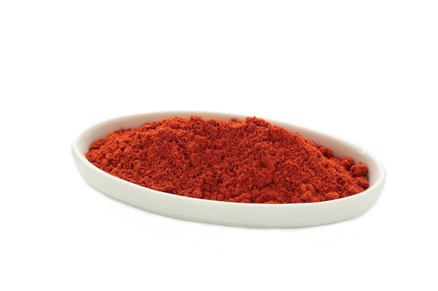 Photo red sweet paprika powder on plate isolated on white background