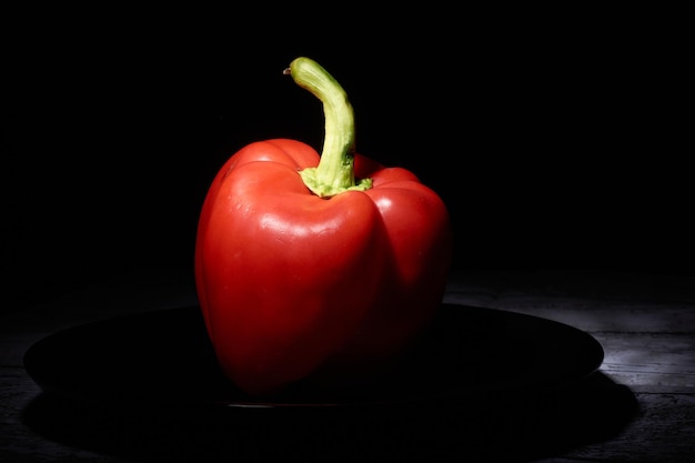 Red sweet pepper on a black background.