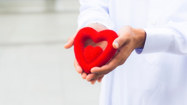 the red symbol heart on the hand of priest or hand of man