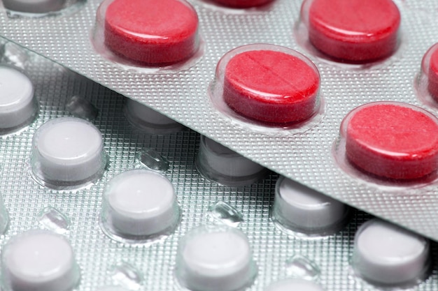 Red tablets in a close-up blister. medical drugs