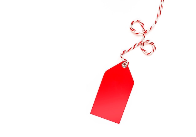 red tag with a rope in the form of a percent sign on a white background