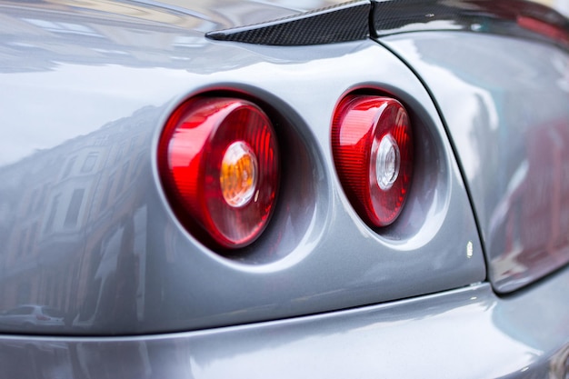 Photo red tail lights rear lights brake lights of grey car close up image