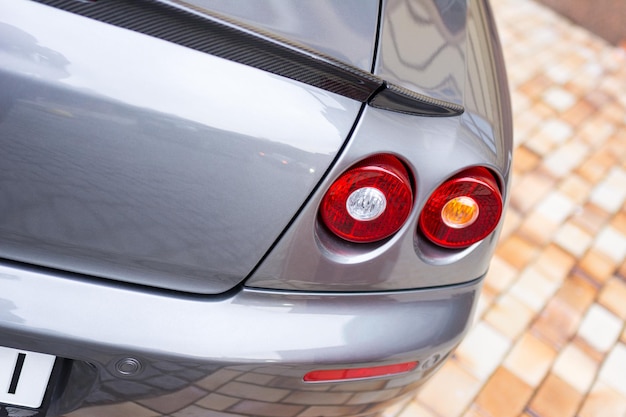 Red tail lights rear lights brake lights of grey car close up image