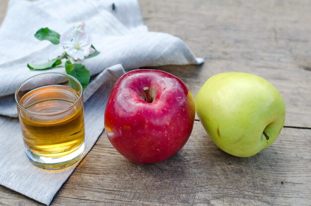 Red and tasty apples with a glass of cider 