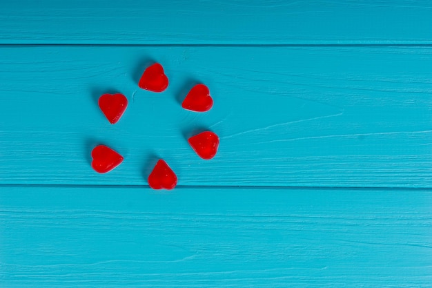 Red tasty jelly candies in the shape of a heart on wooden turquoise table