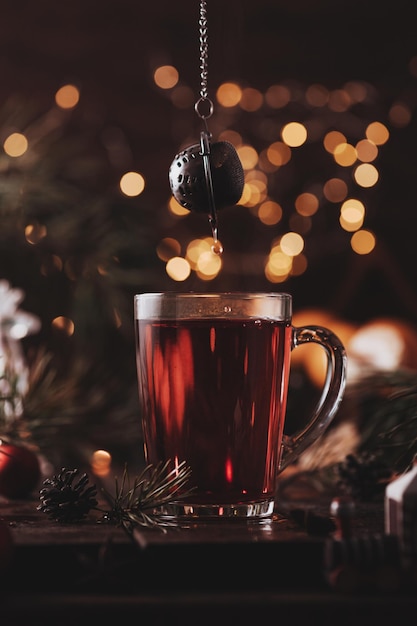 Red tea in a glass. tea drips from a tea strainer on top.