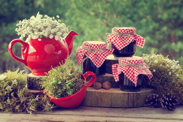 Red teapot tea cup and jars of healthy jam Wedding decorations in rustic style