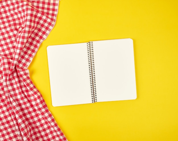 Red textile napkin and open notebook,