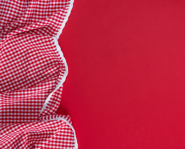 Red textile towel in a white cell on a red background