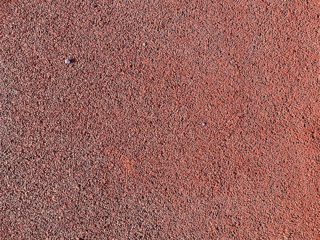 The red texture of the soft rubber surface of the safe cover of the sports playground for workout