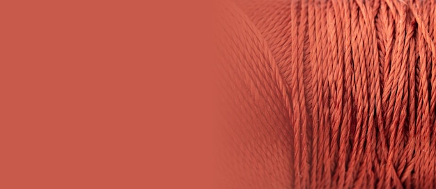 Red thread texture macro closeup copy space A bright banner with a silk thread pattern Sewing minimalistic concept Beautiful abstract background A spool with threads