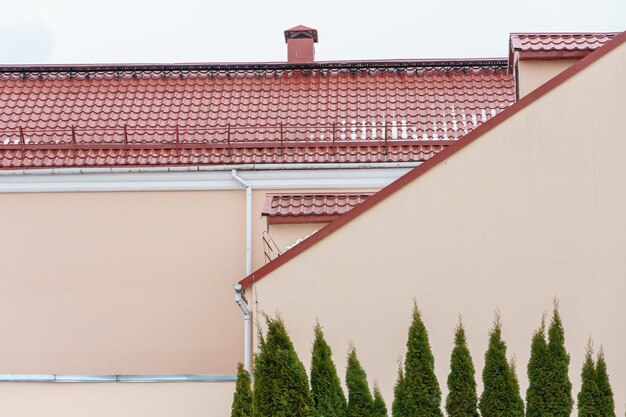 Red tiled roof on a new building after renovation closeup repair of the roof restoration of dilapidated housing insulation of the facade of the house