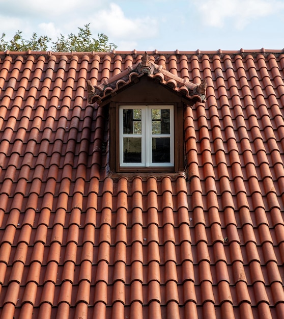 Red tiled roof with attic Dormer window white color on garret rooftop