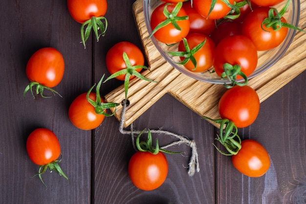 Red tomato in glass bowl on cutting board on wooden table Organic healthy food Cooking Ingredients