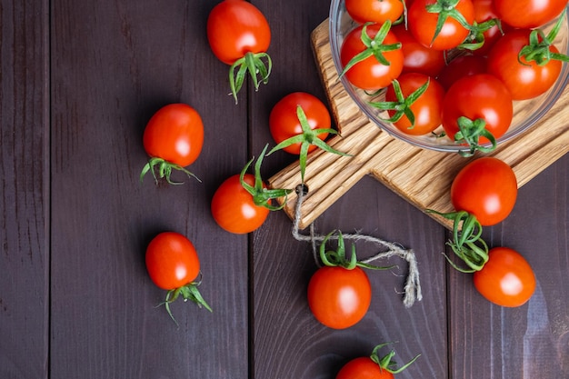 Red tomato in glass bowl on cutting board on wooden table Organic healthy food Cooking Ingredients