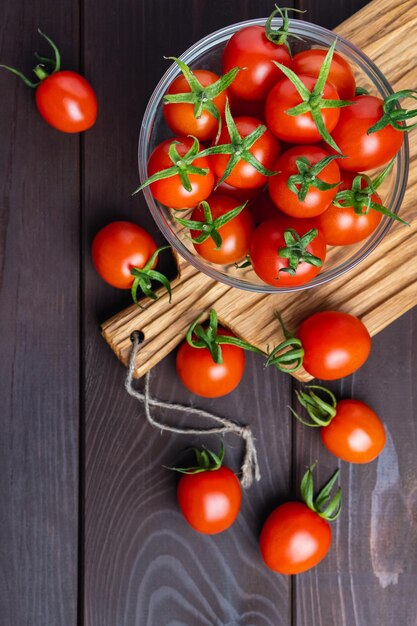 Red tomato in glass bowl on cutting board on wooden table\
organic healthy food cooking ingredients