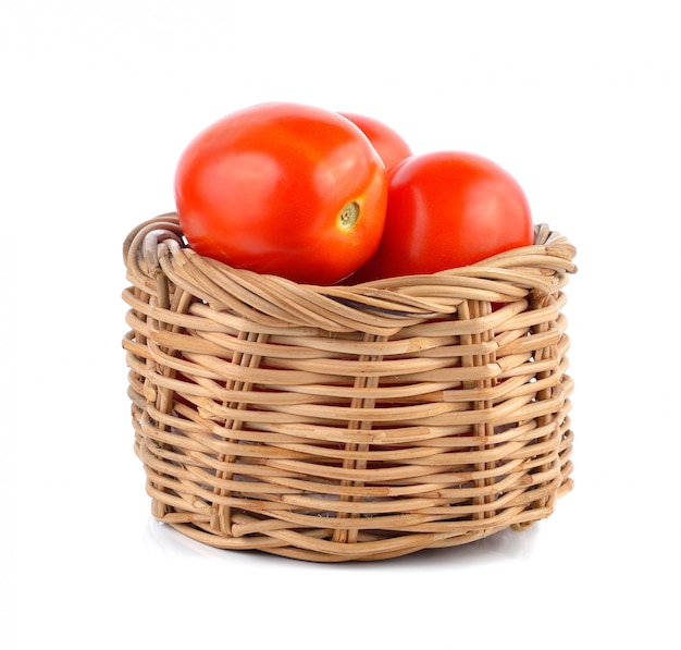 Red tomatoes in the basket on white 