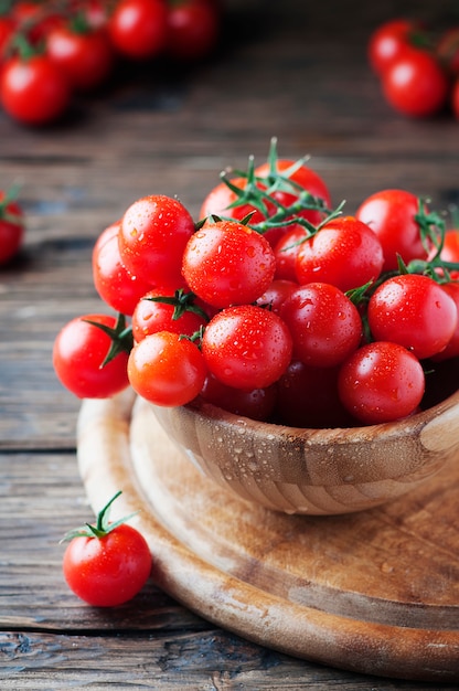 Foto pomodori ciliegia rossi dei pomodori sulla tavola di legno, fuoco selettivo