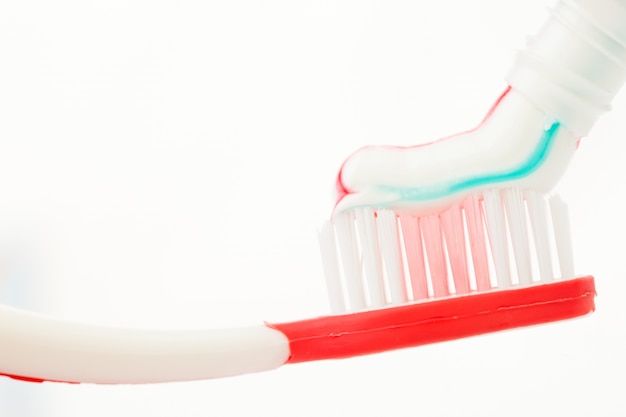 Red toothbrush with multicolour toothpaste