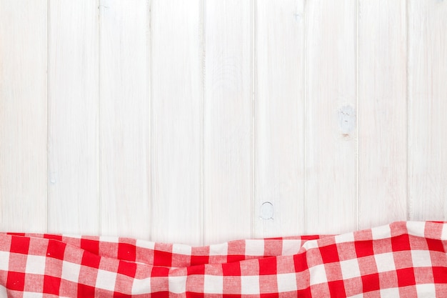 Red towel over wooden kitchen table. View from above with copy space