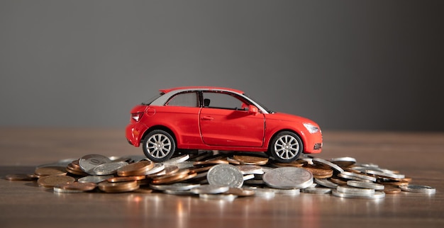 Photo red toy car and coins on the desk