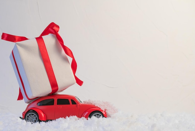 Red toy car on snow covered landscape during winter