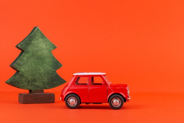 Automobile rossa del giocattolo con un albero di natale