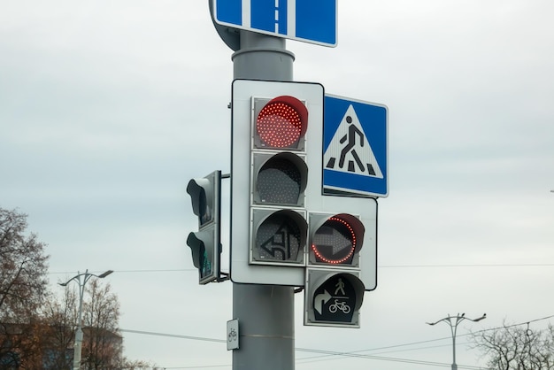 Red traffic light on gray sky background