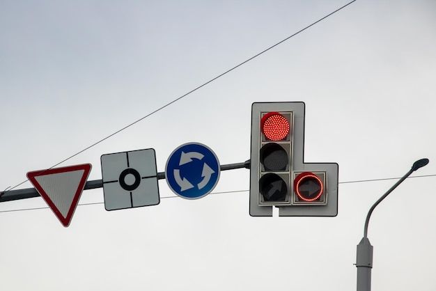 Red traffic light on gray sky background