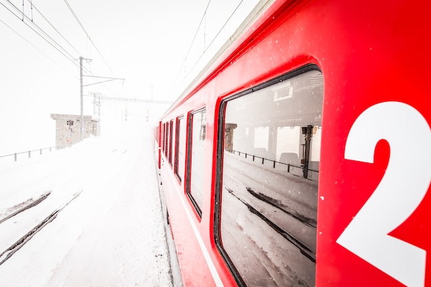 A red train in the middle of a desert of snow