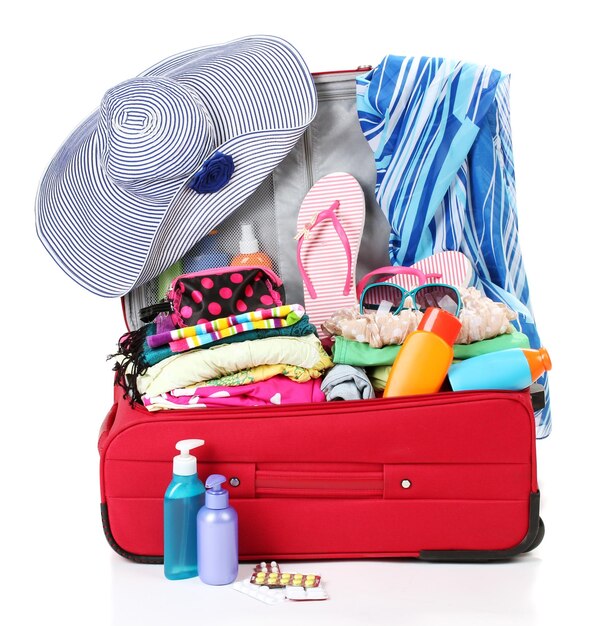 Red travel suitcase with personal belongings isolated on white