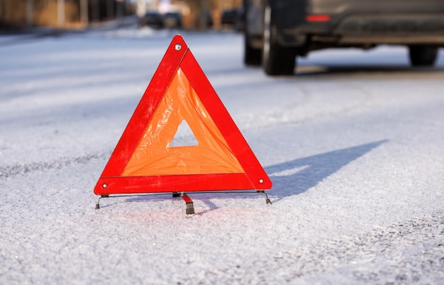 Il triangolo rosso di una fermata di emergenza su una strada invernale al posto di una fermata dell'auto