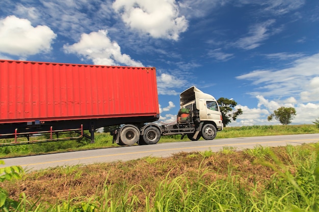 Foto camion rosso sull'autostrada sotto il cielo blu