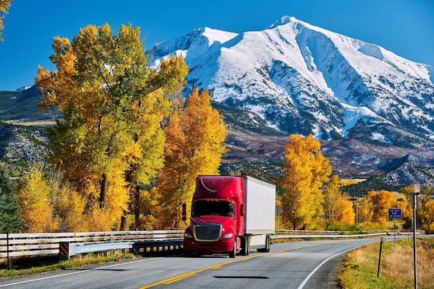 Red truck on highway in Colorado at autumn