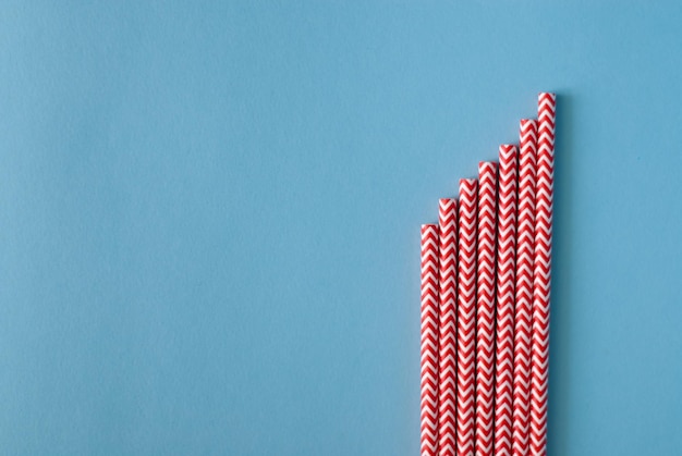 red tubes on a blue background cocktail tubes made of paper