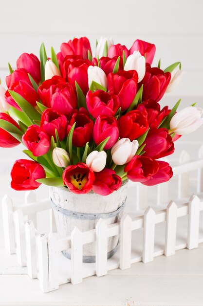 Red tulip bouquet on the white wooden