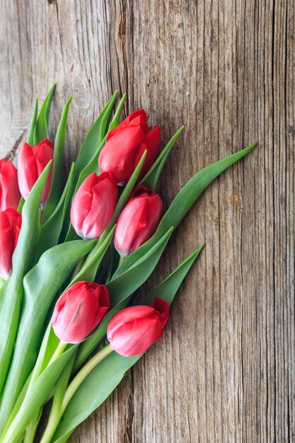 Red tulips bouquet isolated on wooden background