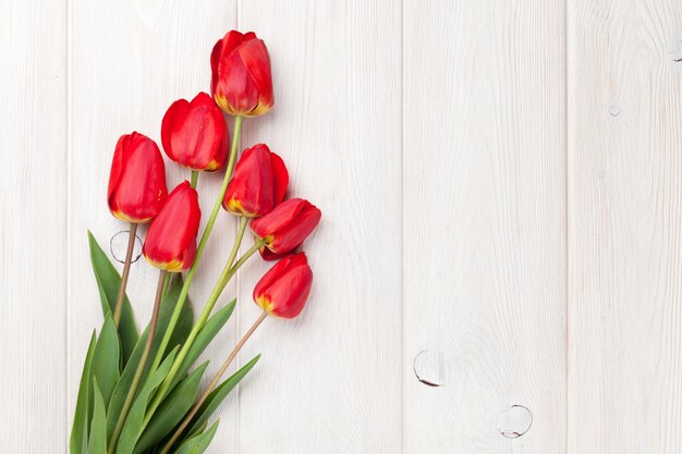 Red tulips bouquet over wood