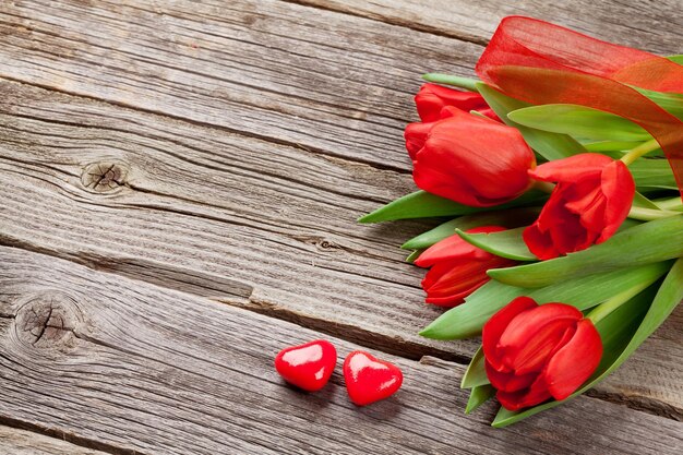 Красные тюльпаны и сердечки конфет дня святого Валентина