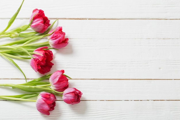 Red tulips on white wooden background