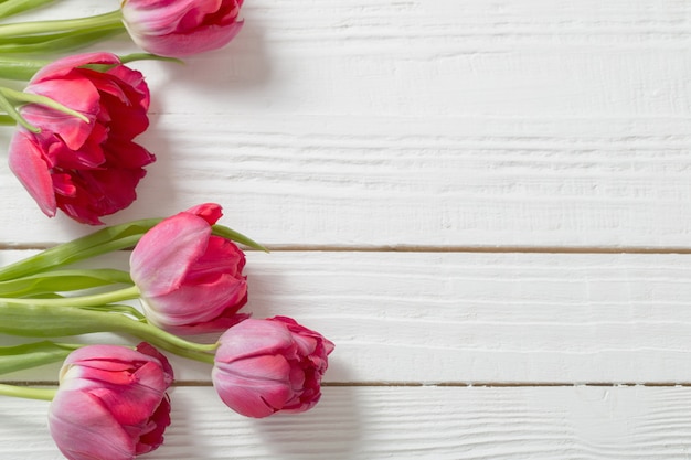 Red tulips on white wooden table