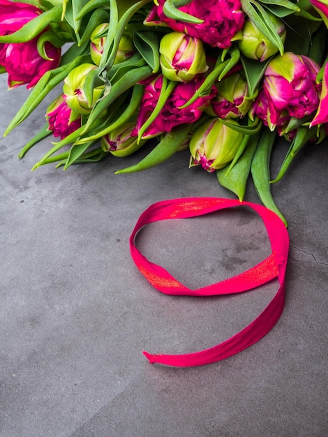 Red tulips with red ribbon isolated on concrete background Victory day or Fatherland defender day