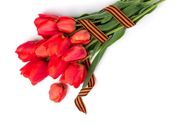 Red tulips with St. George ribbon on white background. Victory day or Fatherland defender day.