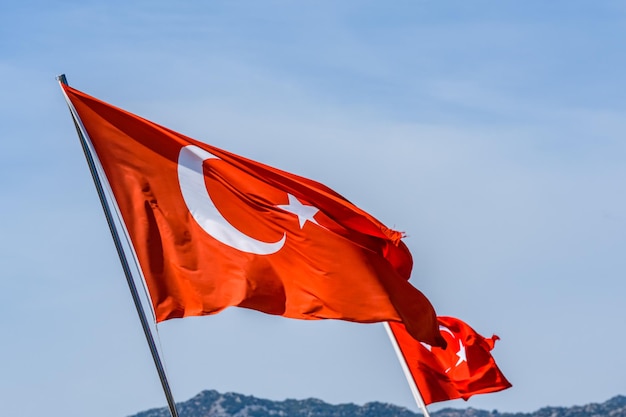 Red turkish flag with crescent and star waving against the sky