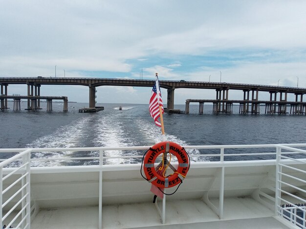 Photo red umbrella on bridge over sea against sky