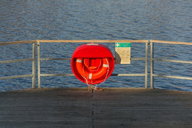 写真 海に向かってロープに吊るされた赤い傘